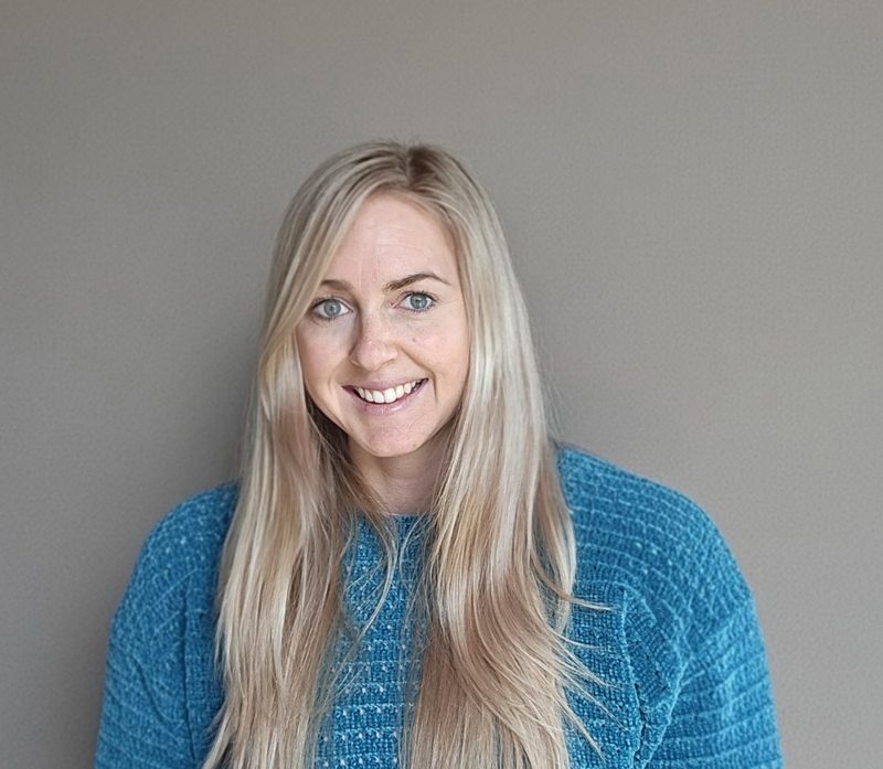 Sammy Rae, smiling, in a teal jumper